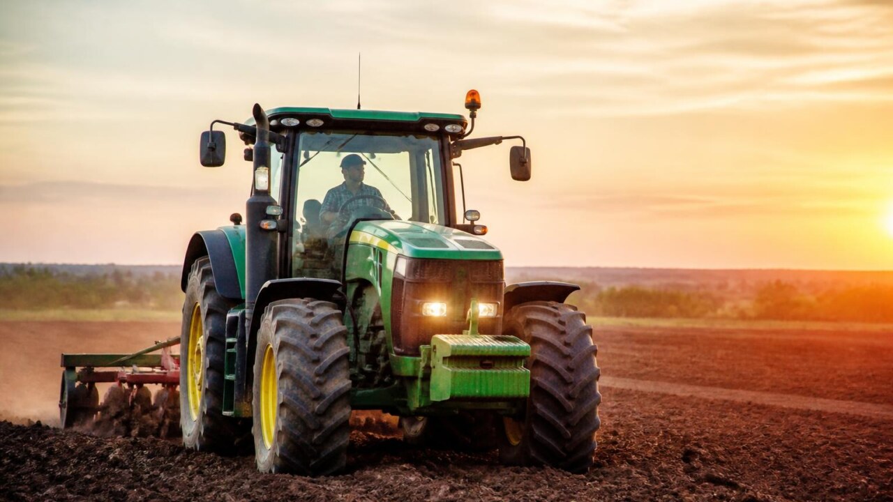 Trator agrícola em operação no campo representando cálculo de custos de utilização