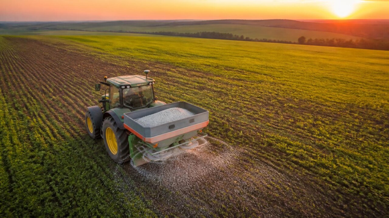 Trator agrícola com sistema de GPS aplicando fertilizante em zonas diferenciadas de um campo